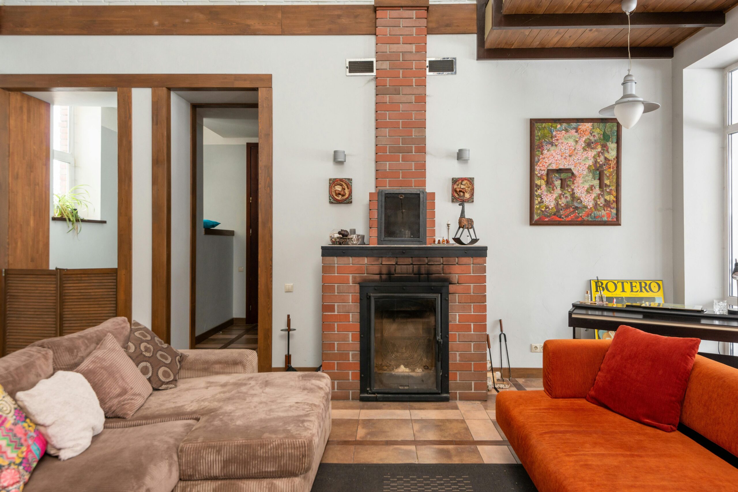 Cozy living room inside a historic home with exposed wooden beams and a large fireplace