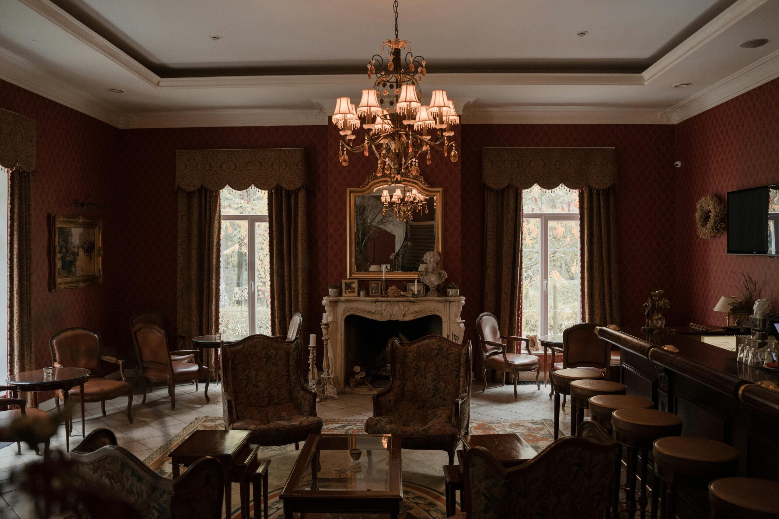 Cozy living room with antique wooden furniture, ornate fireplace mantle, and Persian rug underfoot.