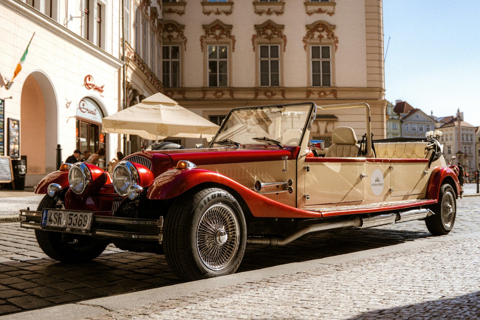 Couple laughing inside a vintage beetle parked near a historic castle.
