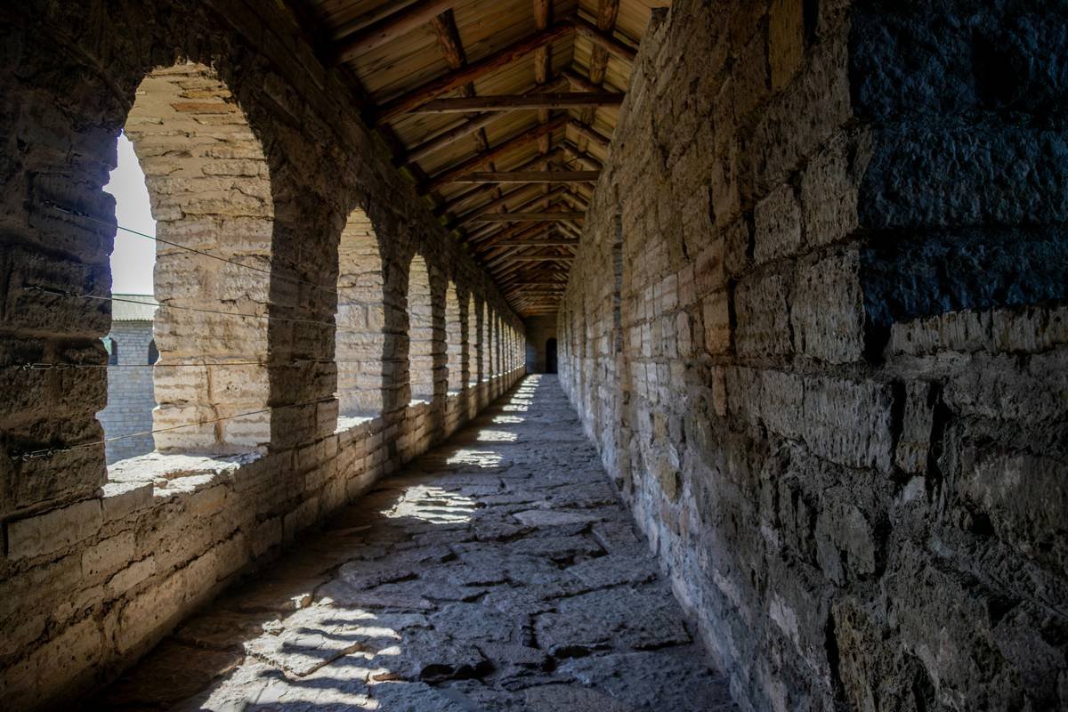 A family posing happily inside a reconstructed medieval dungeon setting.