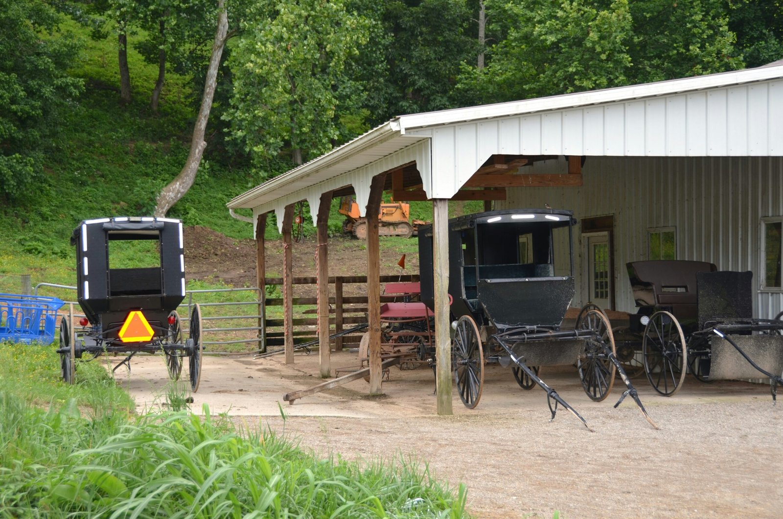 Couple smiling next to a wooden fence overlooking pastures