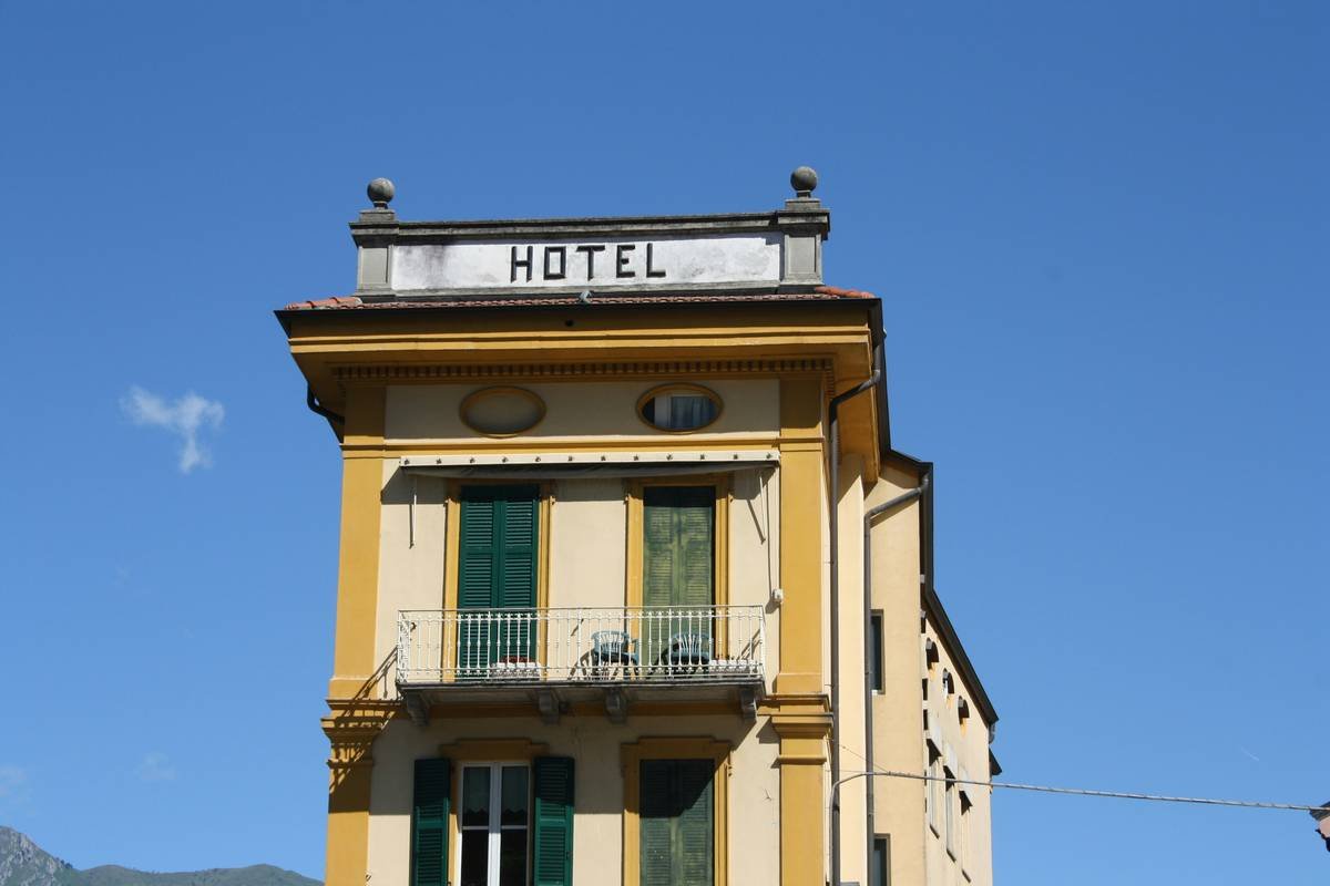 A cozy historic cottage with ivy-covered stone walls and wooden shutters.