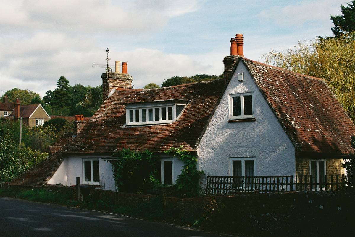 A cozy heritage cottage exterior surrounded by lush greenery