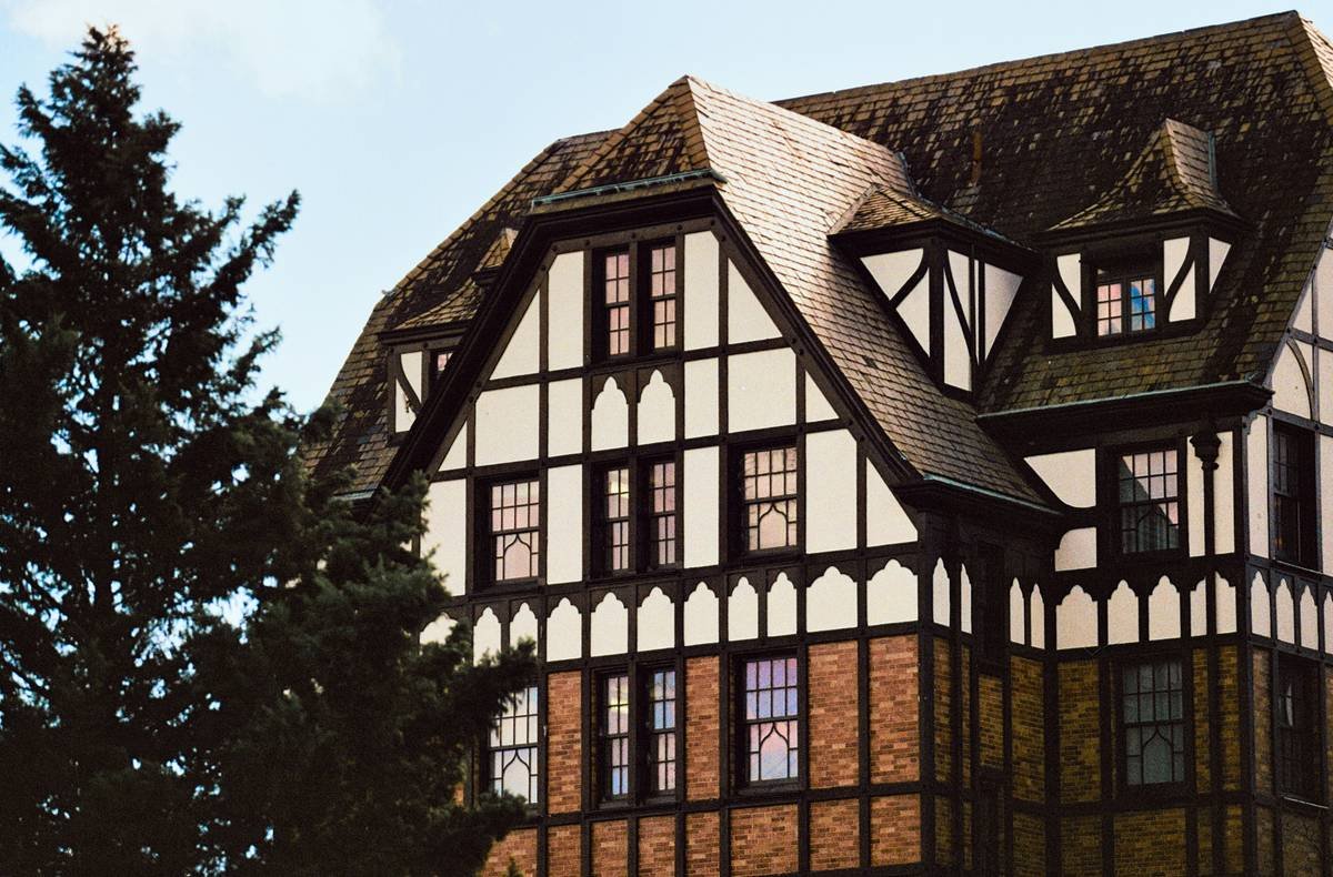 Luxurious interior of a heritage vacation manor featuring antique furnishings and large windows overlooking lush gardens.