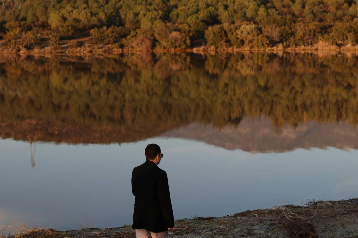 a man standing next to a body of water