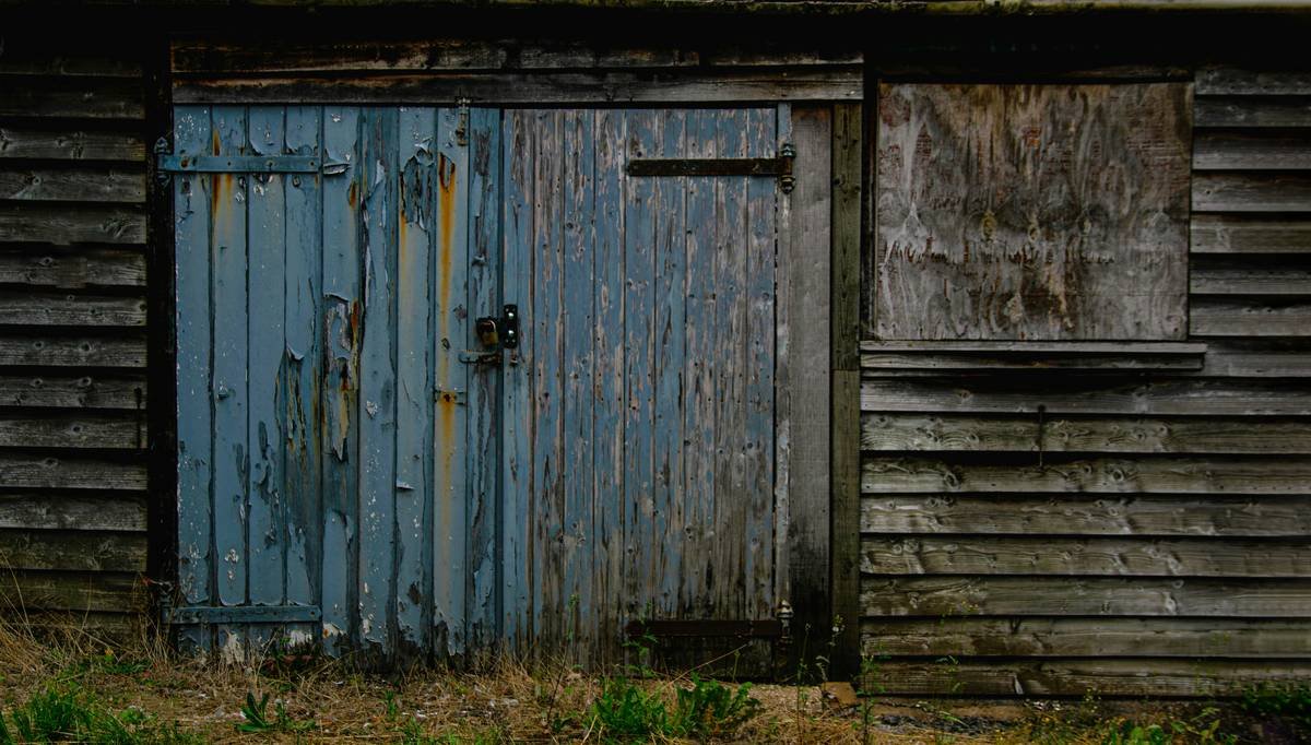 An old wooden shed with a blue door