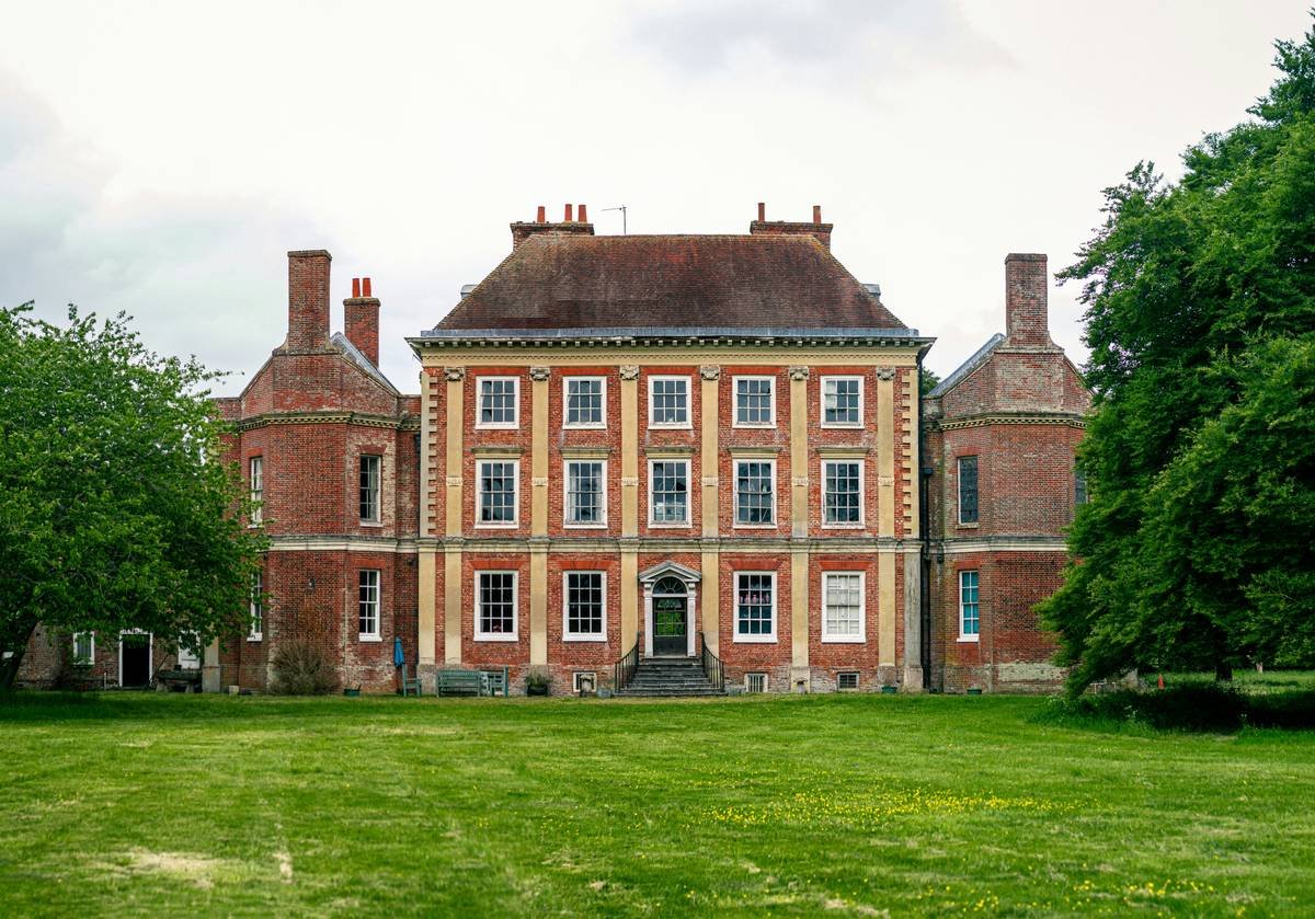 Side-by-side comparison: authentic 17th-century English manor with original oak beams vs. modern rental with faux antiques and plastic chandeliers