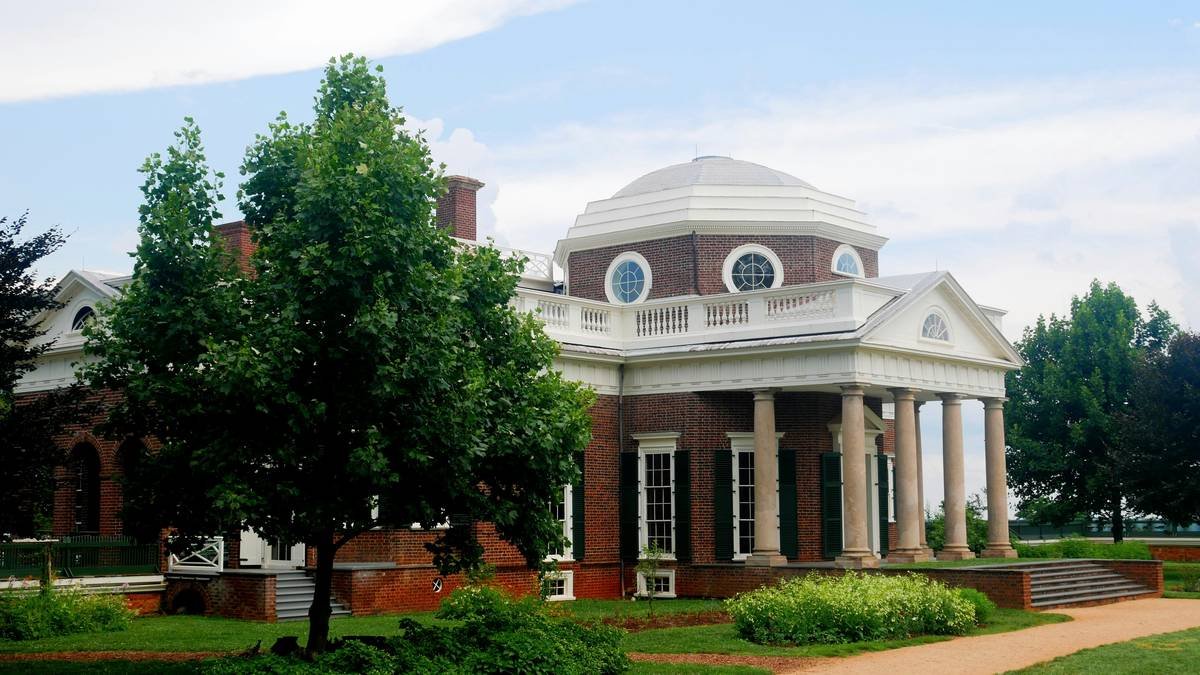 Exterior of a restored 18th-century brick home with white shutters, showcasing historic williamsburg vacation rentals