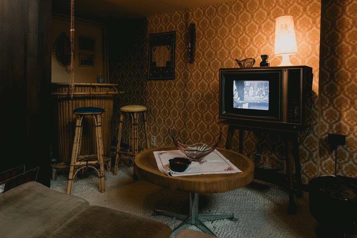 furnishing a vacation rental with vintage armchair, brass lamps, and exposed brick walls